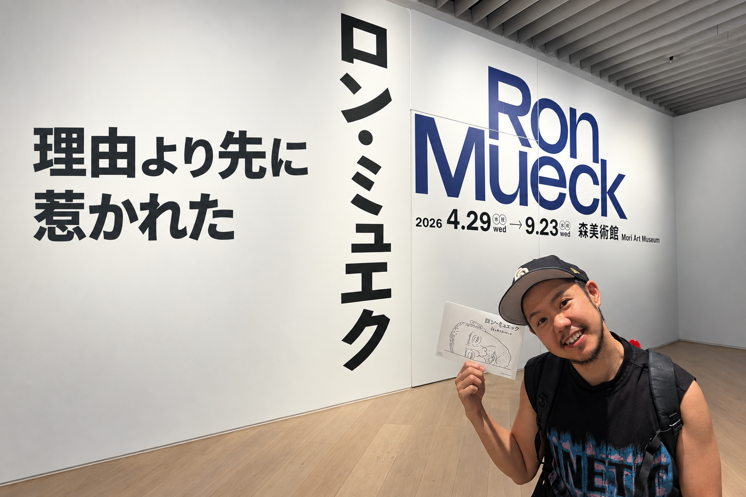 森美術館のロン・ミュエク展入口で展示案内を手にする筆者